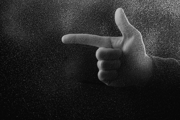 abgeschnittene Aufnahme einer Person, die in der Dunkelheit mit dem Finger wegzeigt  - Foto, Bild