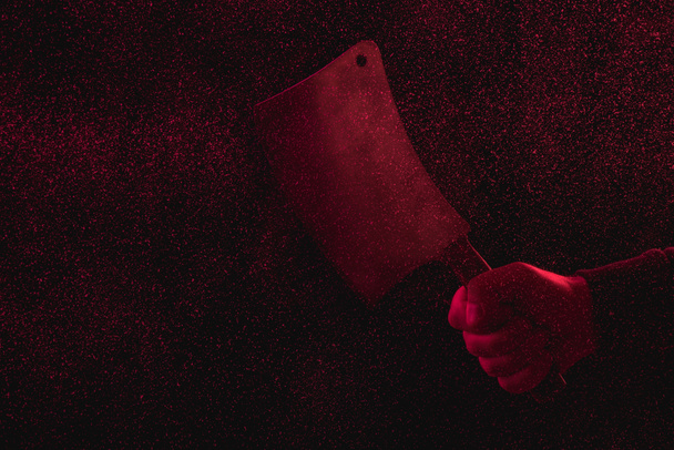 περικοπεί shot του άνδρα να κρατάει μαχαίρι κρέατος στο κόκκινο φως - Φωτογραφία, εικόνα