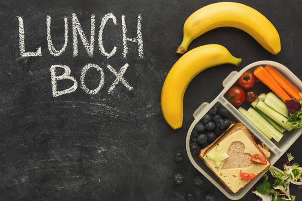 Cajas de almuerzo llenas de comida saludable en pizarra negra
 - Foto, Imagen