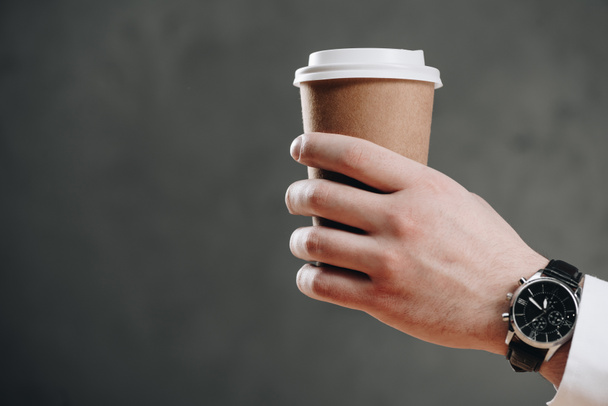 περικοπεί shot επιχειρηματία κρατώντας χαρτί Κύπελλο με τον καφέ για να πάει σε γκρι - Φωτογραφία, εικόνα