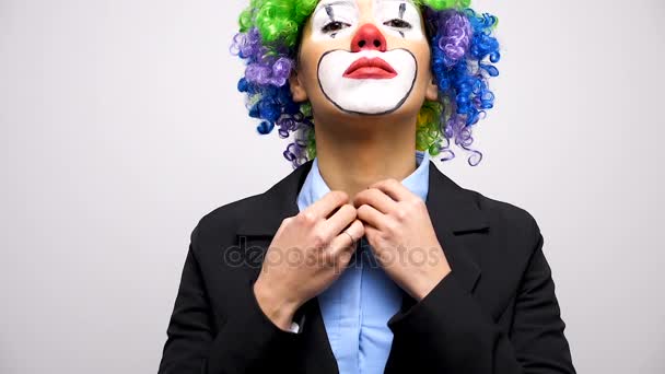 Клоун в парике и деловом костюме закрывает пуговицу от рубашки
 - Кадры, видео