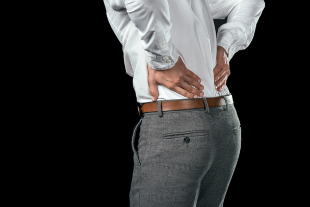 cropped view of businessman having pain in back, isolated on black - Fotoğraf, Görsel