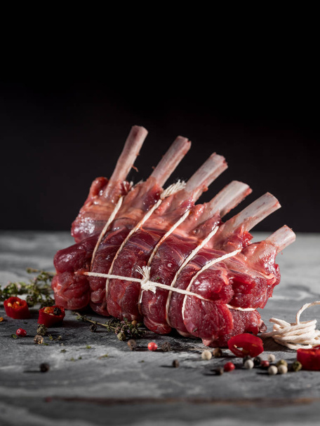 close-up of raw knitted Beef Ribs with spices on table background  - Фото, изображение