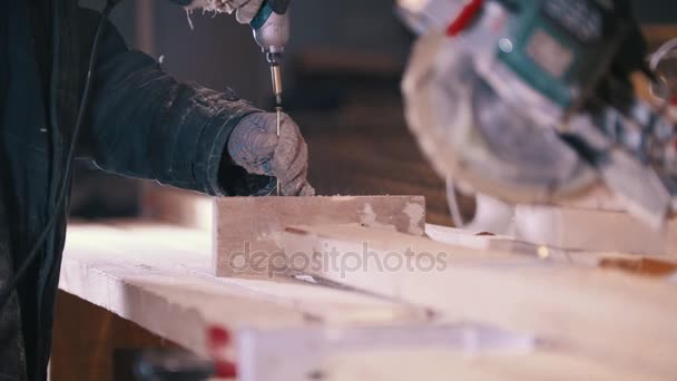 Werknemer zet de schroeven in houten plank op schrijnwerkerij - Video