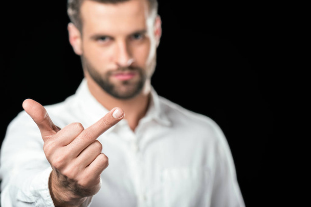 selective focus of man showing middle finger, isolated on black - Φωτογραφία, εικόνα