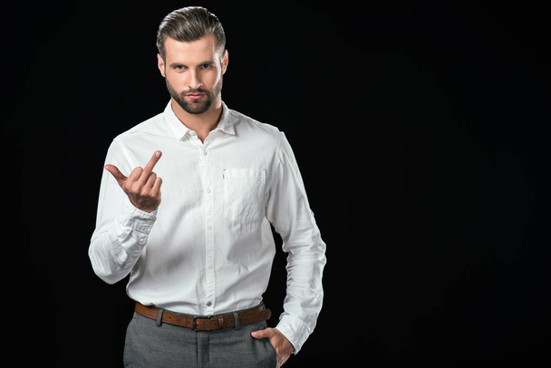 handsome man showing middle finger, isolated on black - Photo, Image