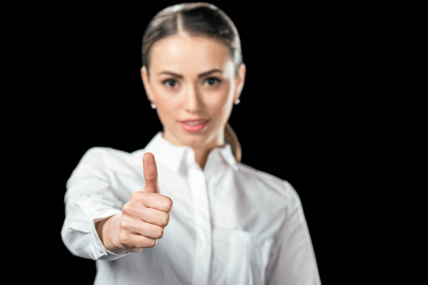 selective focus of businesswoman showing thumb up, isolated on black - Фото, изображение