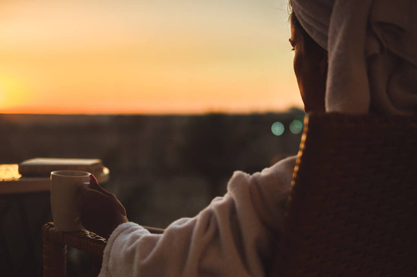 Mädchen genießen Kaffee beim Blick auf den Sonnenuntergang - Foto, Bild
