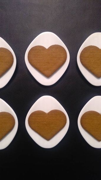 kalp şeklinde kurabiyeler (6) beyaz daireler ve siyah arka plan üzerinde. Üstten Görünüm. yakın çekim, dikey ve kırpılmış resim. - Fotoğraf, Görsel