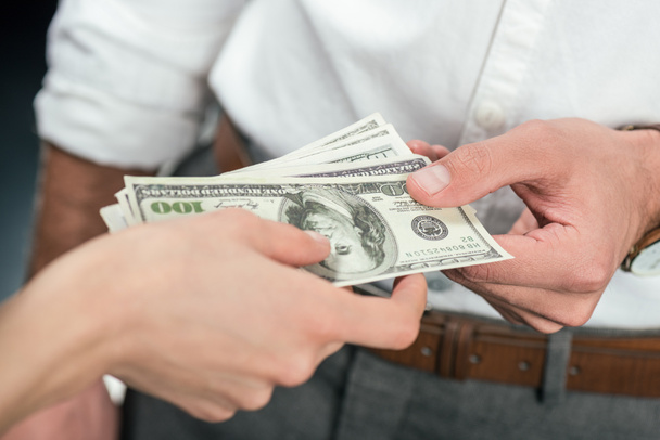 обрізаний вид бізнесменів, що тримають доларові банкноти, ізольовані на чорному
 - Фото, зображення