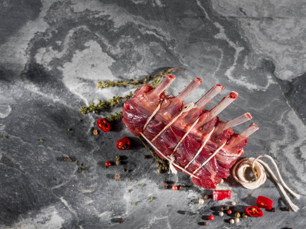 close-up de costelas de carne de bovino de malha crua com especiarias em fundo cinza
  - Foto, Imagem