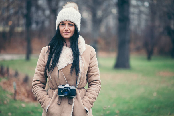 Female photographer taking pictures outdoors with a vintage camera - Foto, Bild