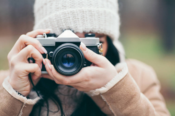 Female photographer taking pictures outdoors with a vintage camera - Foto, imagen