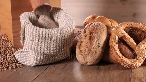 Zbliżenie do mąki i piekarnia produktów w pobliżu worek mielenia pszenicy - Materiał filmowy, wideo
