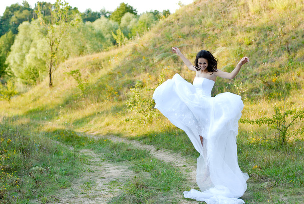 Young beautiful bride on green lawn passage - 写真・画像