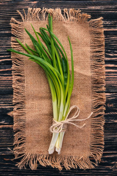 Fresh green onion on a wooden background. Top view. Free space for your text. - Photo, Image