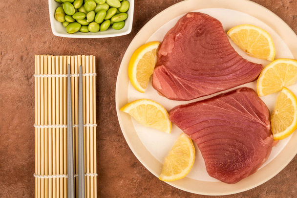 Fresh Raw Uncooked Yellow Fin Tuna Steaks With Lemon Slices - Zdjęcie, obraz