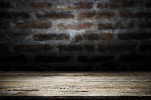Holz Tischplatte auf alten dunklen Backstein-Hintergrund. - Foto, Bild