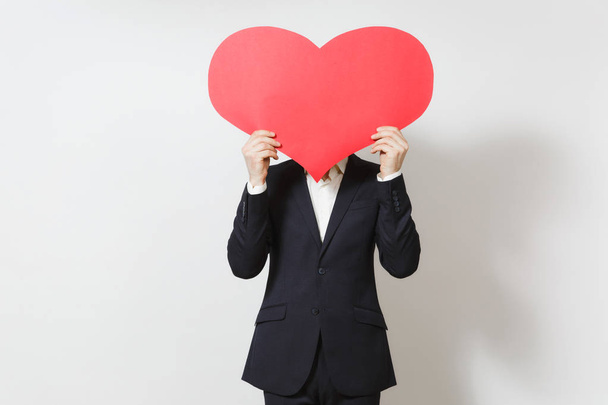 Young man in suit covering face by big red heart isolated on white background. Copy space for advertisement. Place for text. St. Valentine's Day, International Women's Day, birthday, holiday concept. - Foto, Imagen