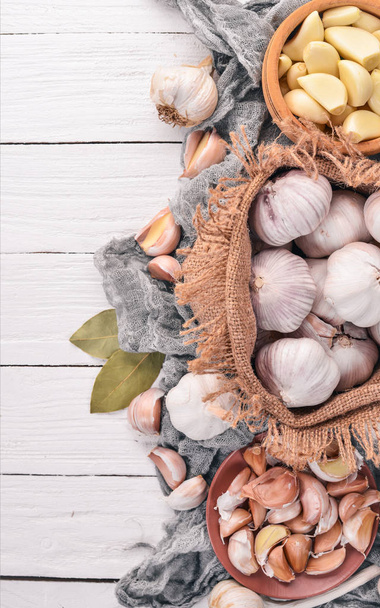 Garlic. A set of fresh garlic on a white wooden background. Top view. Copy space. - Fotó, kép