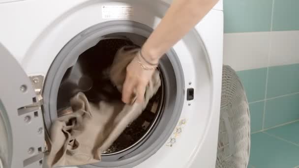 Háziasszony kitölti mosodai-kosárból mosógép, és a gép ajtó zárak - Felvétel, videó