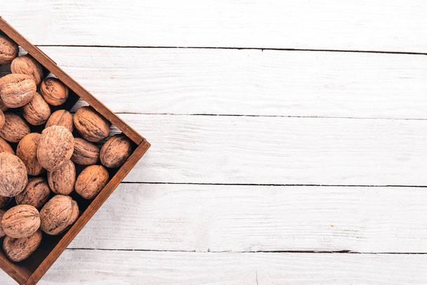 Walnut. In a box on a wooden background. Top view. Copy space. - Φωτογραφία, εικόνα