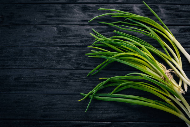 Fresh green onion on a wooden background. Top view. Free space for your text. - Foto, Bild