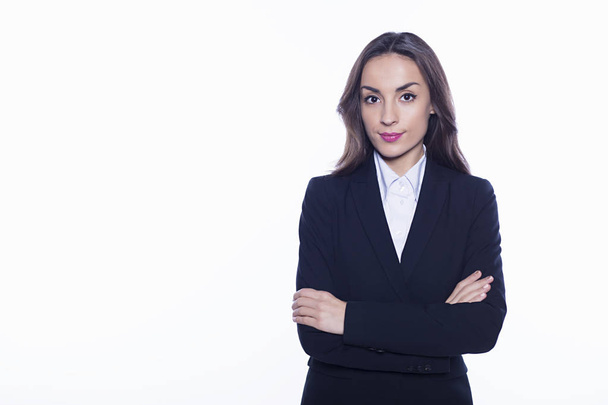 Young smiling confident business woman looking directly into the camera with arms crossed isolated on white background. Concept of office work. - Fotografie, Obrázek