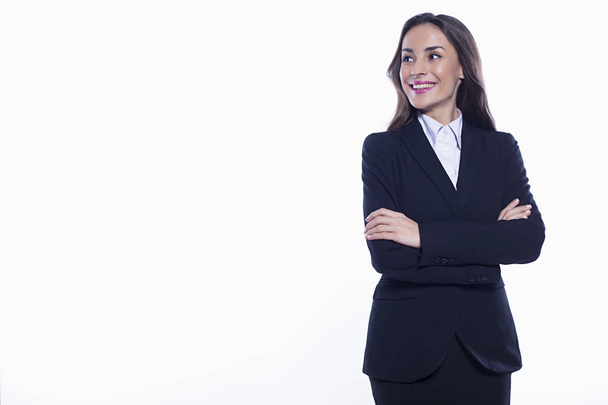 Young smiling confident business woman looking directly into the camera with arms crossed isolated on white background. Concept of office work. - Фото, изображение