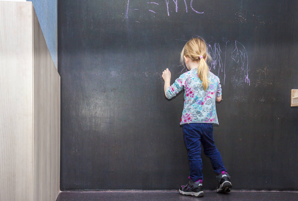 Petite fille mignonne écrivant sur tableau
 - Photo, image