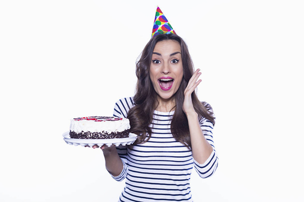 This is a very tasty cake. Beautiful birthday girl holding a big cake but refusing it isolated on a white background. - Foto, imagen
