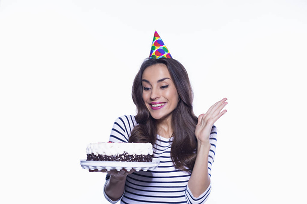 This is a very tasty cake. Beautiful birthday girl holding a big cake but refusing it isolated on a white background. - Photo, Image