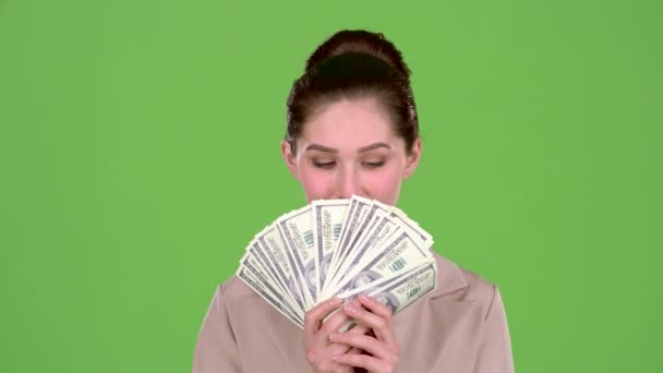 Girl with banknotes of money in her hands, winks at the guy she likes. Green screen - Footage, Video