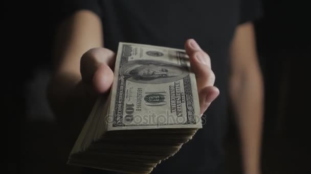 Primo piano di un uomo che dà un barile di banconote da un dollaro. Il concetto di salario. Carità
. - Filmati, video