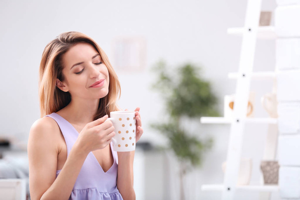 Молодая женщина с чашкой чая, расслабляющая дома
 - Фото, изображение