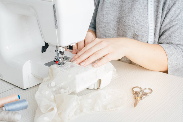 Young seamstress working on sewing machine - Foto, Bild