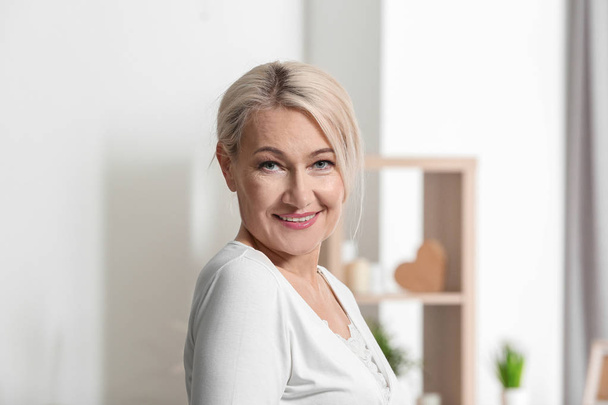 Portrait of beautiful mature woman at home - Foto, afbeelding