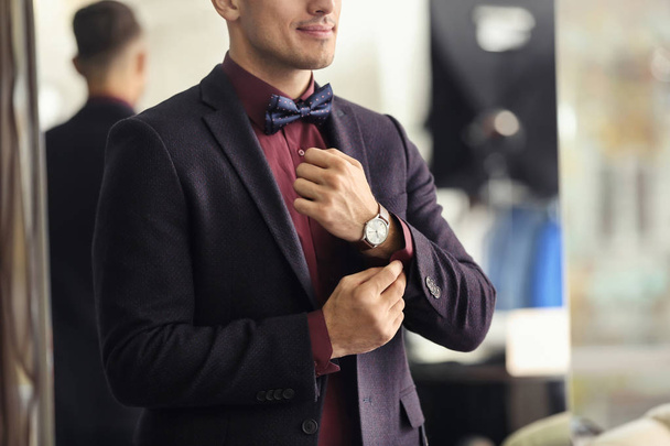 Young man in elegant suit on blurred background - Φωτογραφία, εικόνα