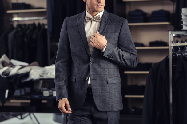 Young man in elegant suit at menswear store - Foto, afbeelding