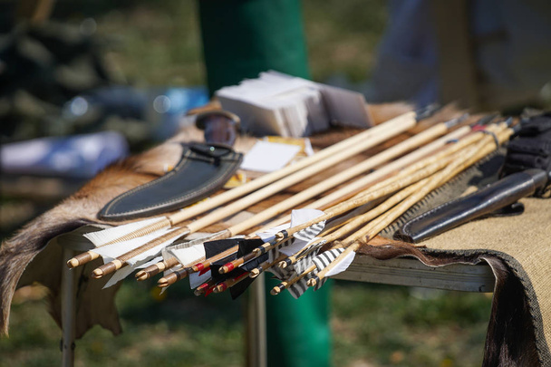 Flèches en bois de style ancien sur la table avec couteau chasseur
 - Photo, image