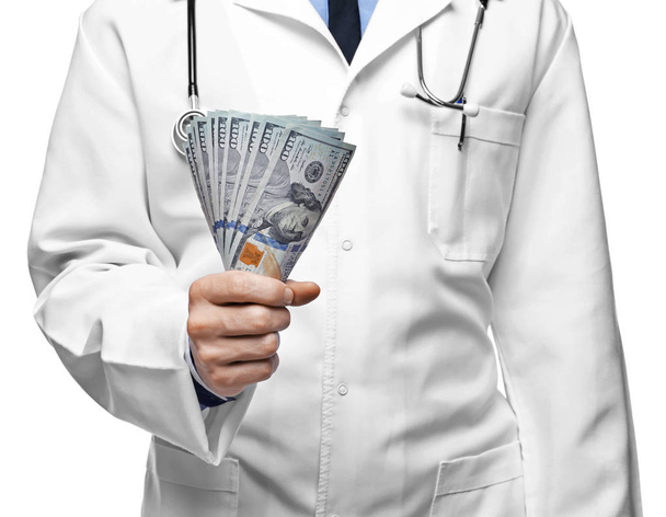 Doctor with money on white background. Corruption concept - Фото, изображение