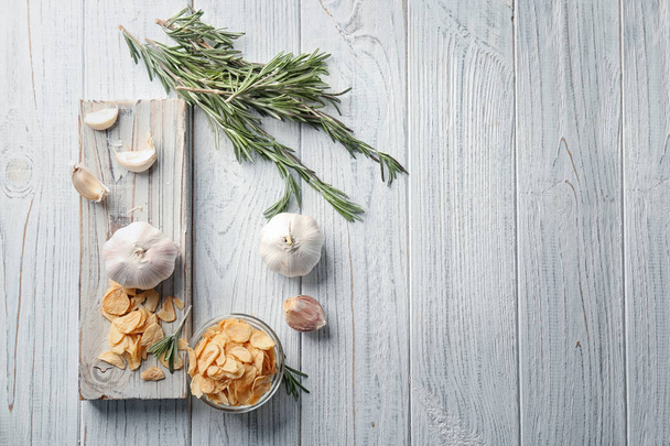 Composition with dried garlic flakes on wooden background - Foto, Imagem