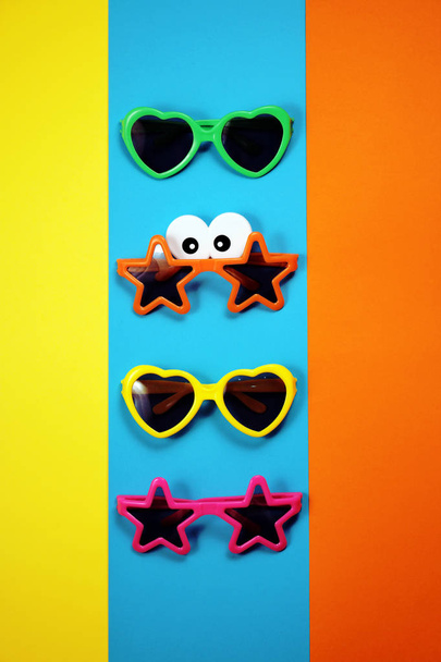 Various shapes of Sunglasses on multicolored background - Foto, Imagen