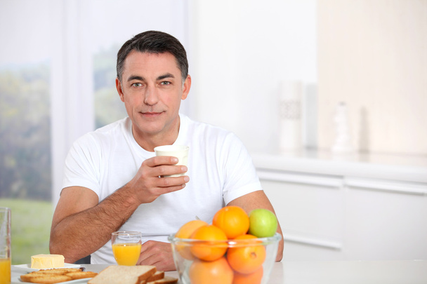 Smiling adult man having breakfast - Фото, зображення