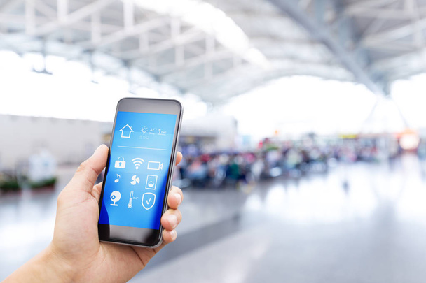Smartphone mit Smart Home und moderner Flughafenhalle - Foto, Bild