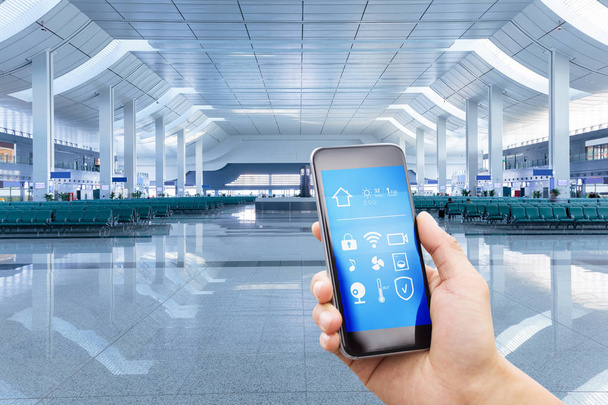 smartphone con hogar inteligente y sala de aeropuerto moderna
 - Foto, Imagen