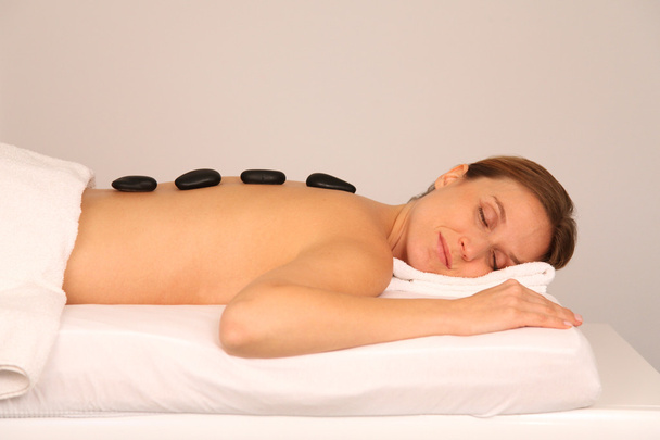 Woman having a massage with hot stones - Foto, Imagem