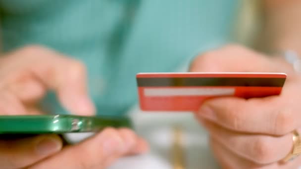 Mężczyzna kupuje towary w sklepie internetowym i płaci karty kredytowej za pośrednictwem jej telefon - Materiał filmowy, wideo
