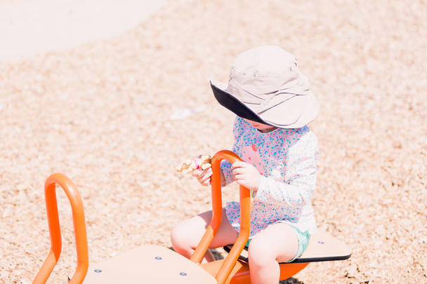 маленька дівчинка грає на дитячому майданчику
 - Фото, зображення