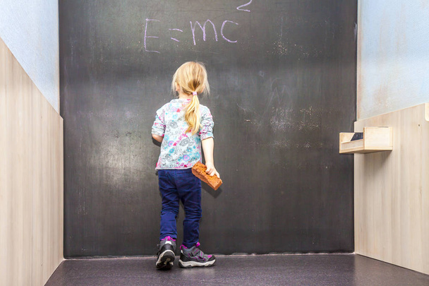 Милая маленькая девочка пишет на доске
 - Фото, изображение